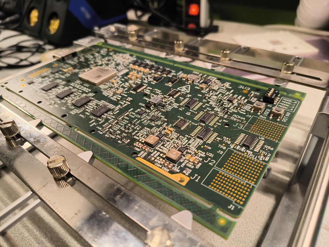 Placa de processamento montada num gabarito de ensaio, com paquímetro